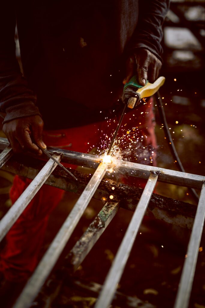 Close-up of a welder creating sparks while working on metal fabrication.