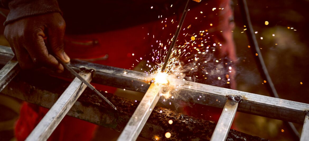 Close-up of a welder creating sparks while working on metal fabrication.